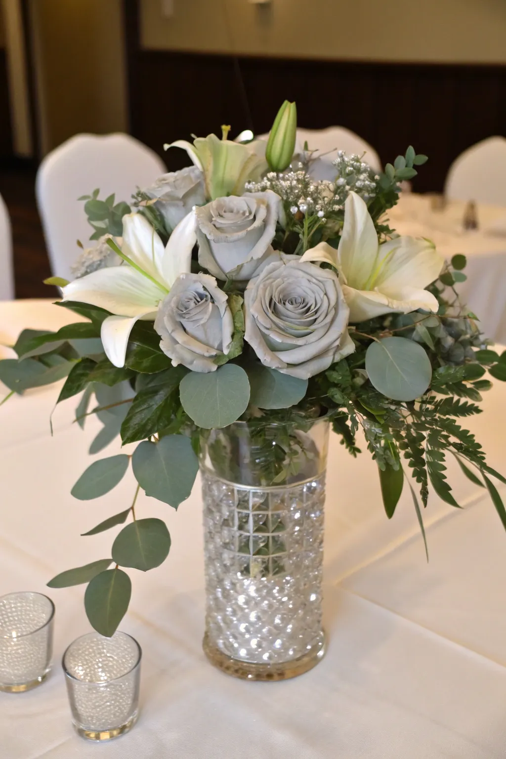An elegant floral centerpiece with a touch of silver for a 25th anniversary celebration.