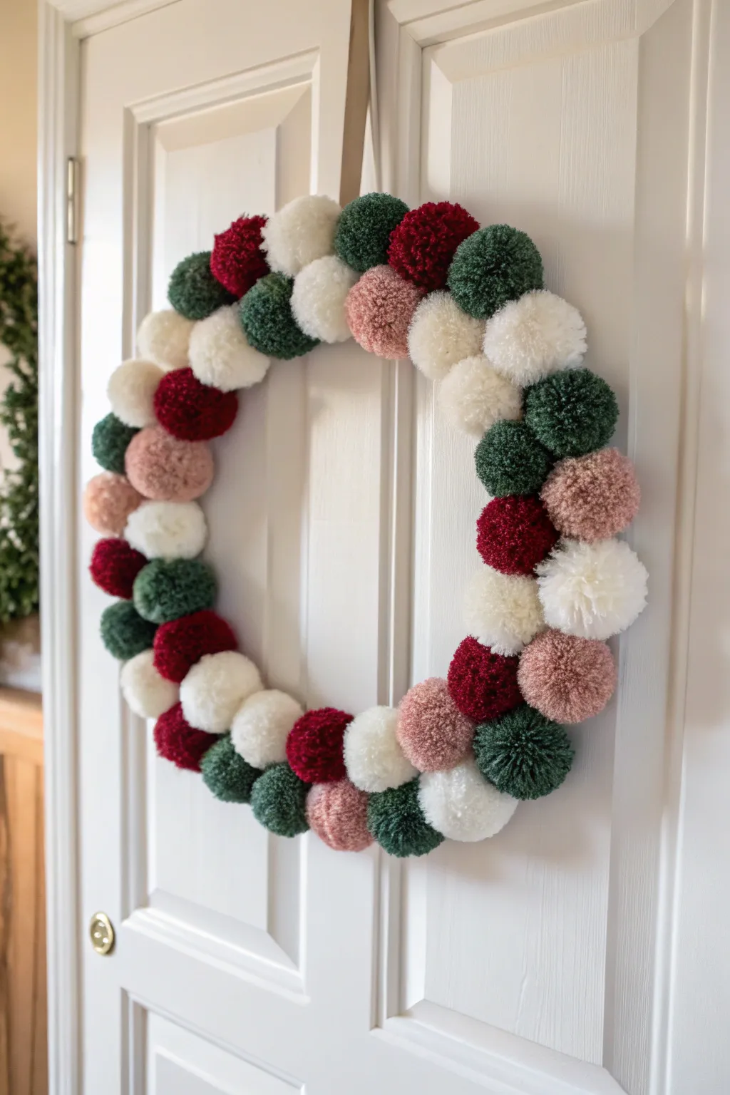 Add a touch of handcrafted elegance to your holiday decor with a charming pom pom wreath.