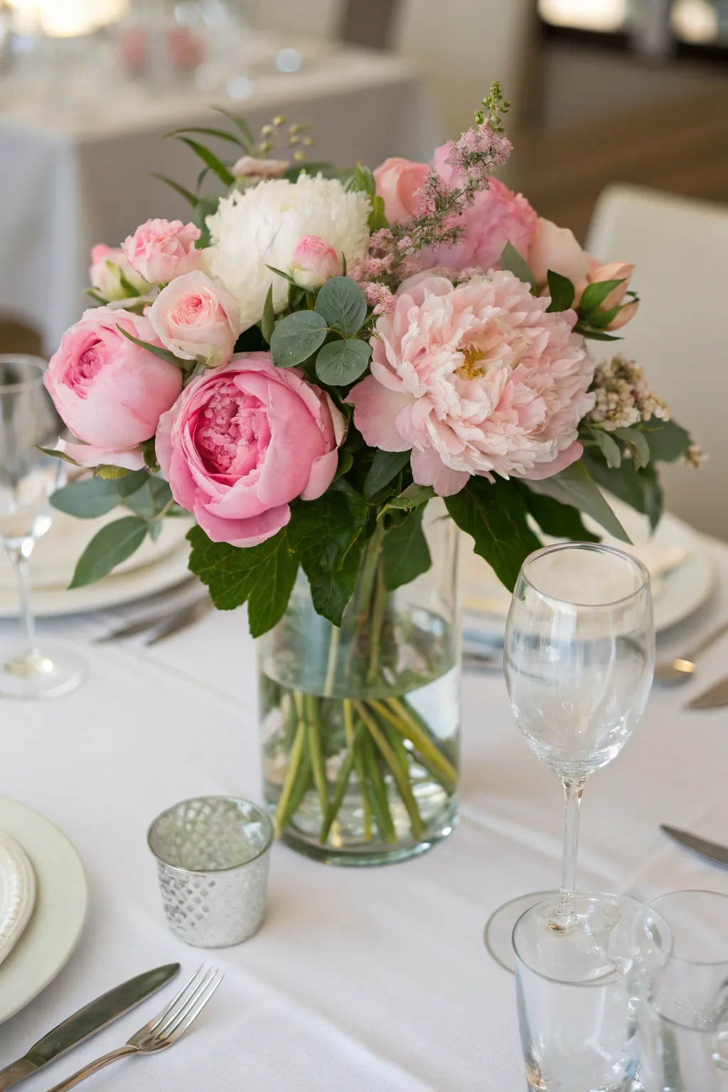 A lush floral centerpiece with pink peonies and roses.