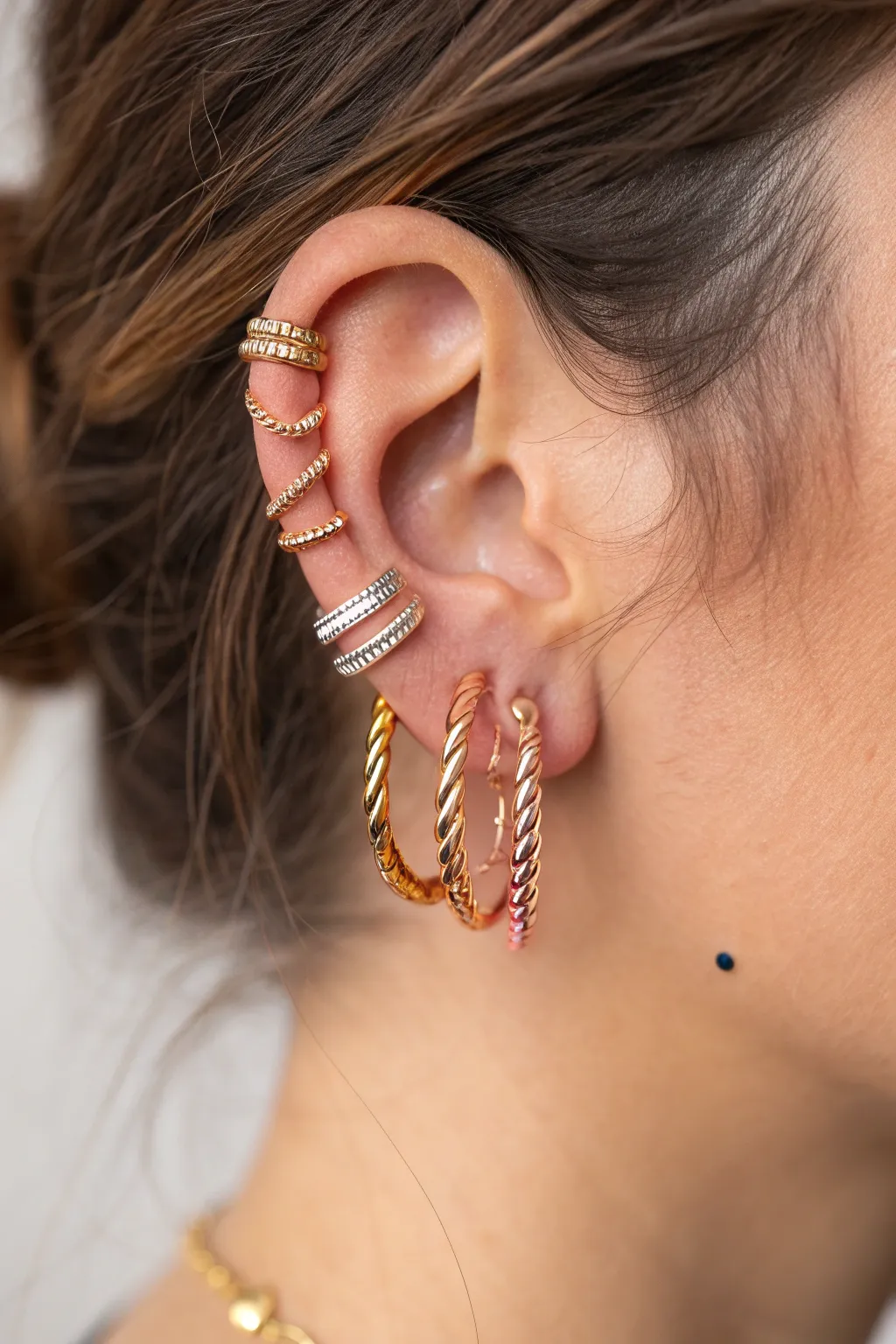 Elevate your ear party with a stunning blend of gold, silver, and rose gold for a chic, layered look.