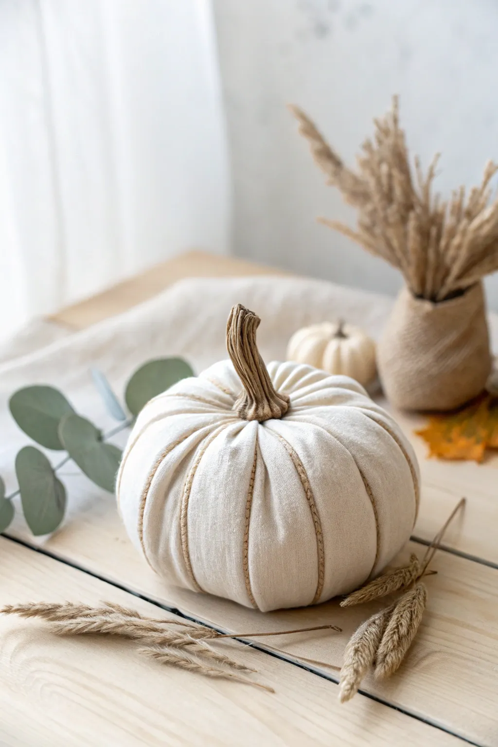 Elevate your autumn decor with a touch of rustic elegance—raffia-wrapped fabric pumpkins bring natural beauty to your space.
