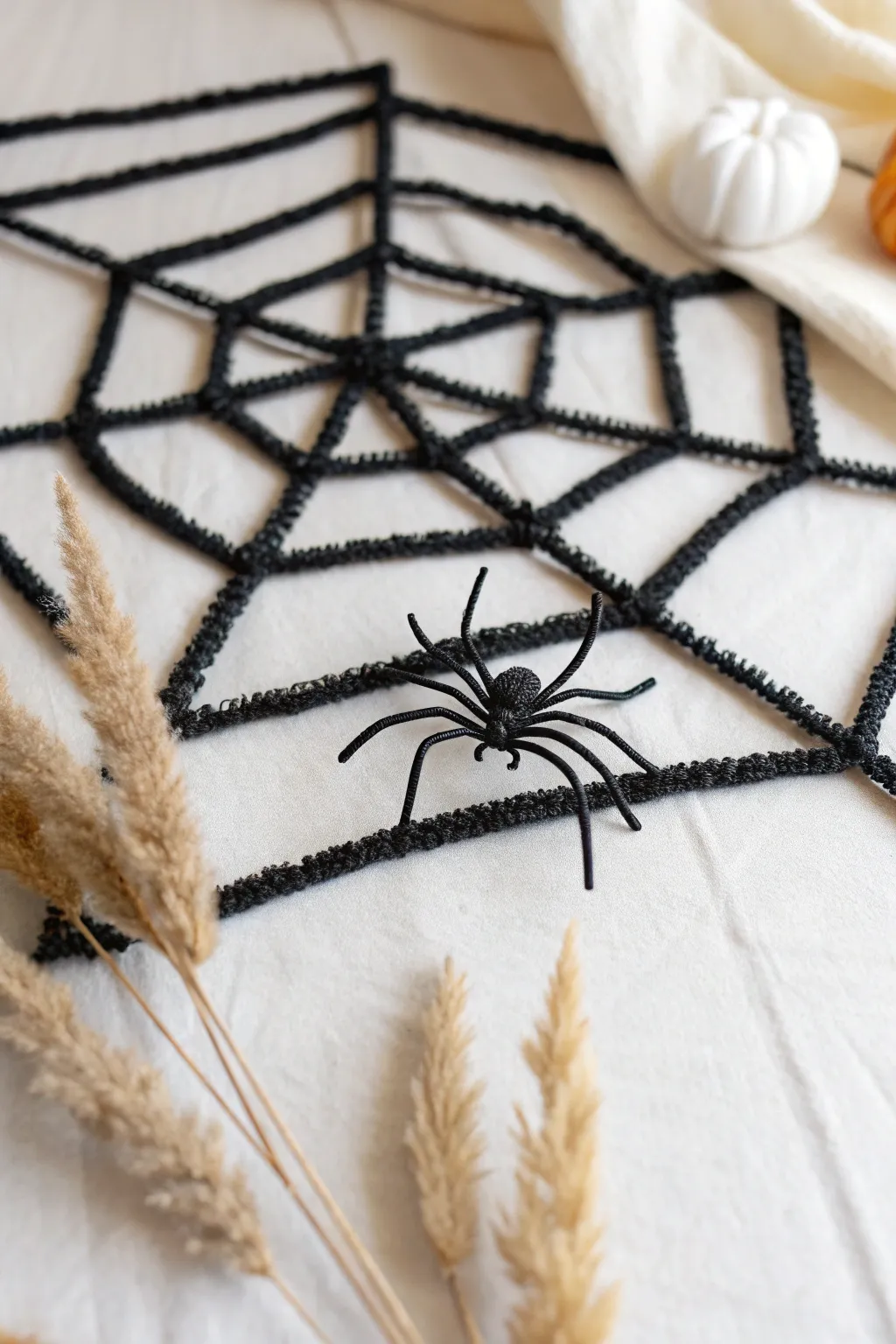 Unravel the mystery: A minimalist twist on Halloween with a handcrafted pipe cleaner web.