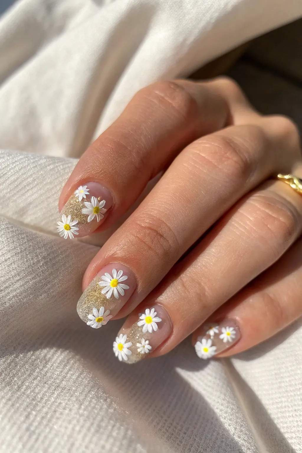 Embrace elegance with minimalist daisy nails adorned with a hint of glitter for that perfect sparkle.