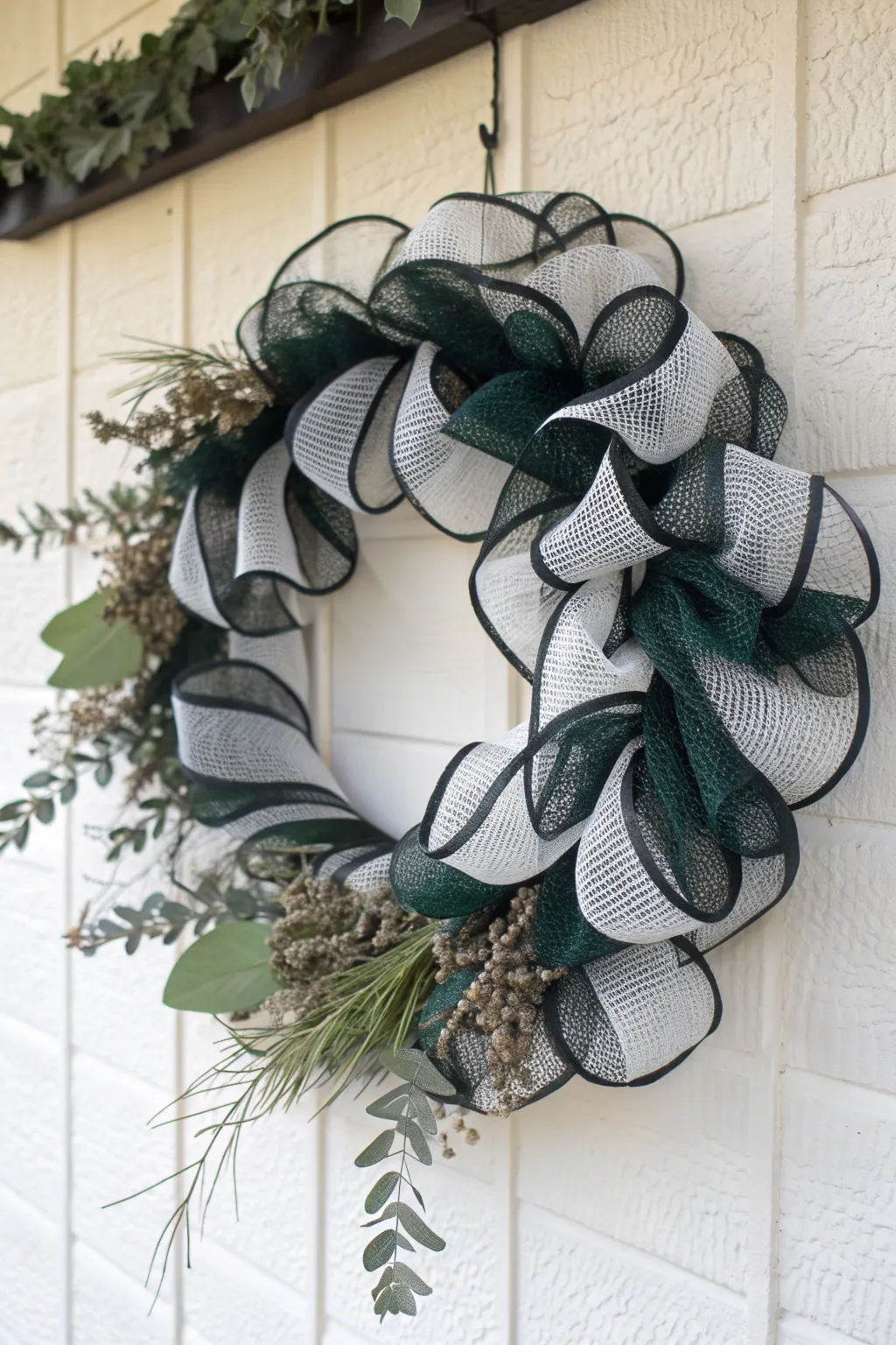 Embrace Minimalist Mystique: A chic deco mesh wreath in monochrome with a bold twist of green.