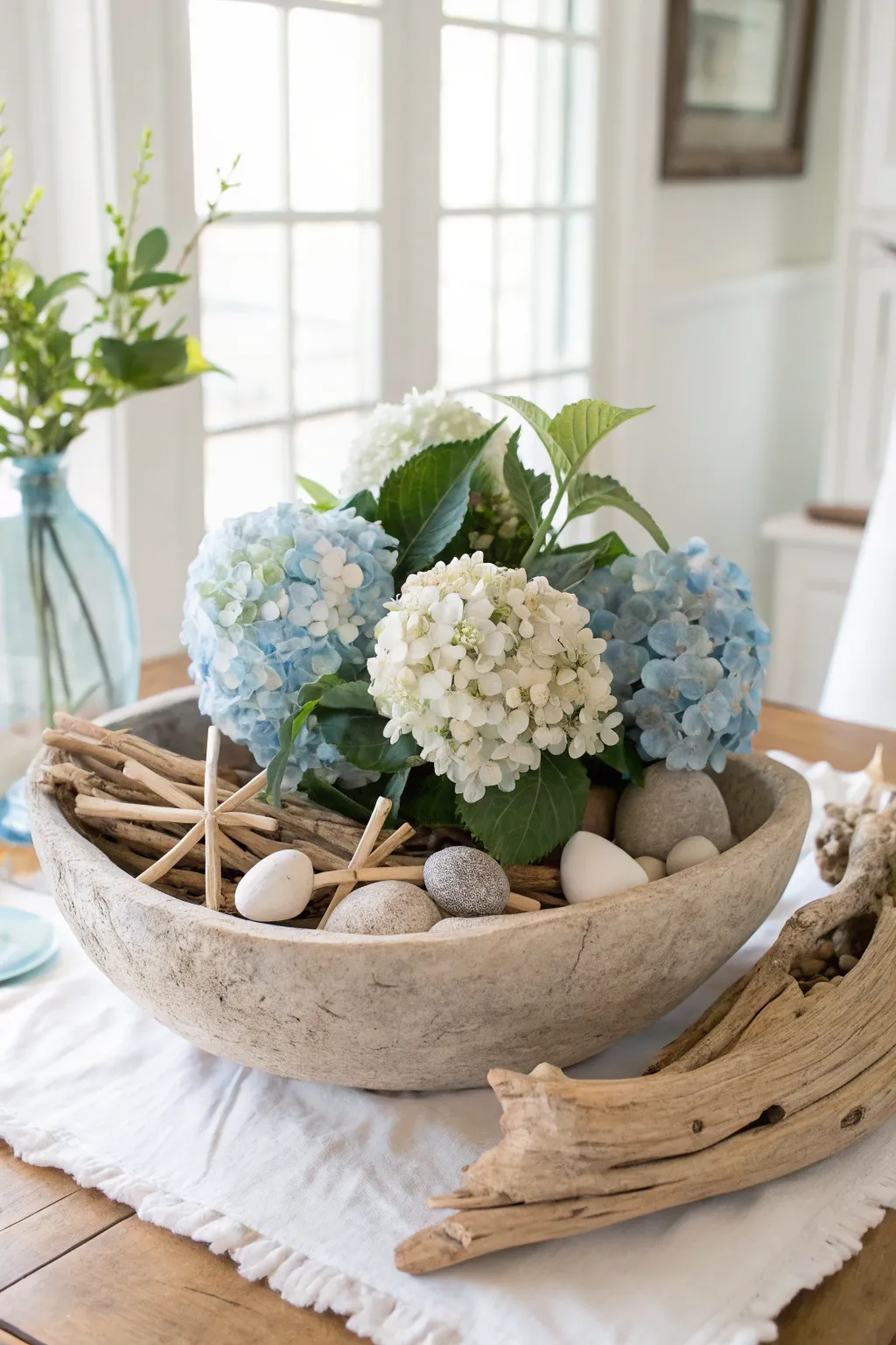 Capture coastal charm with hydrangeas and driftwood for a breezy spring ambiance.