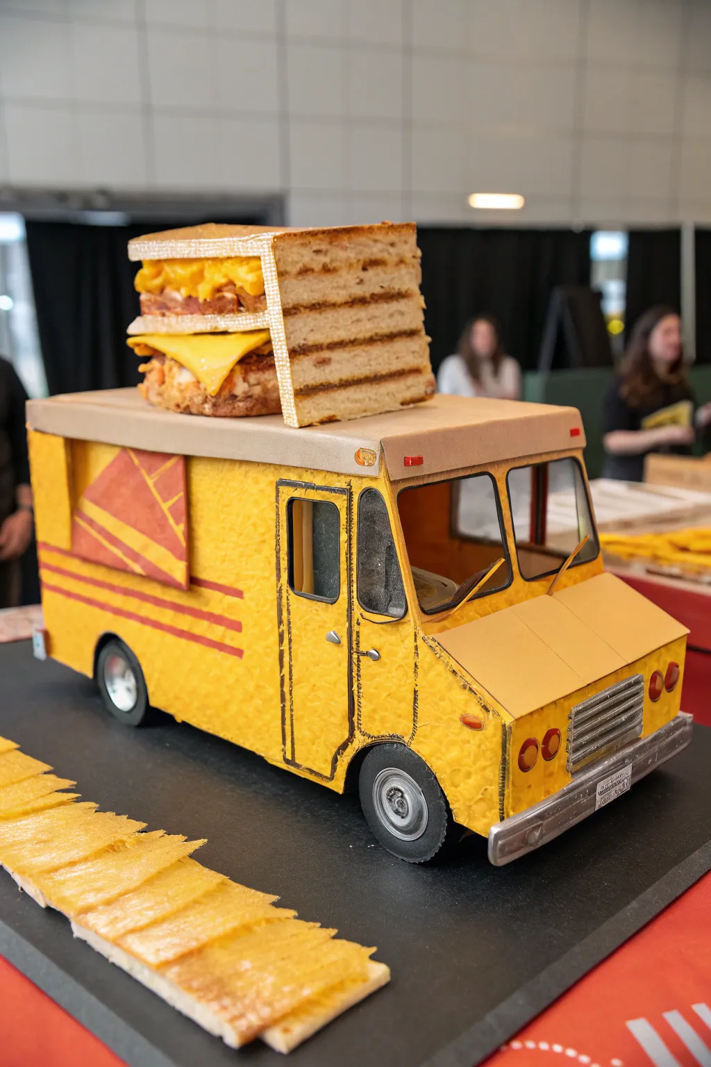 Indulge in the art of gourmet grilled cheese with this intricately crafted cardboard food truck. A masterpiece in yellow and orange hues!
