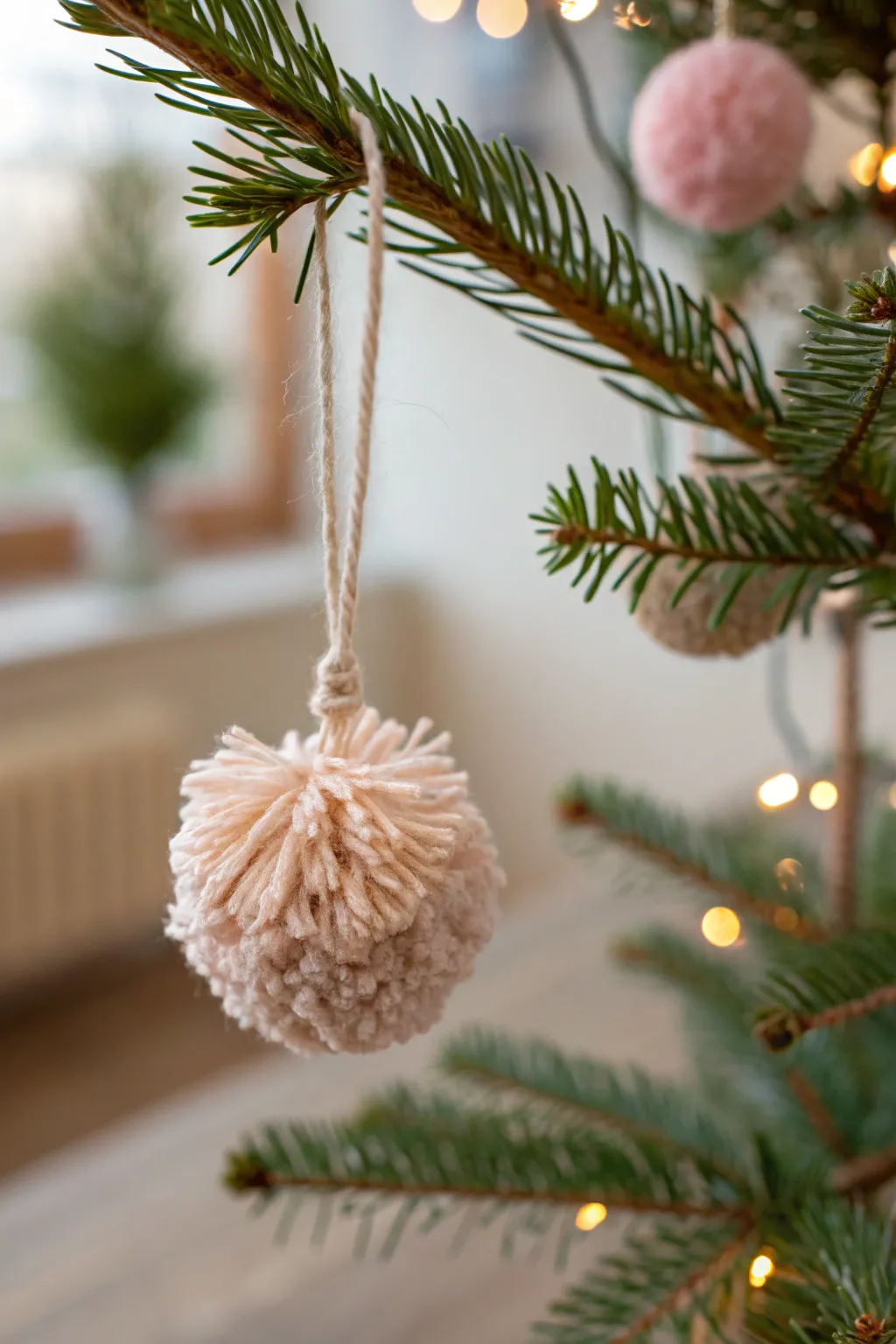 Add a touch of handmade elegance to your festive decor with charming pom pom ornaments.