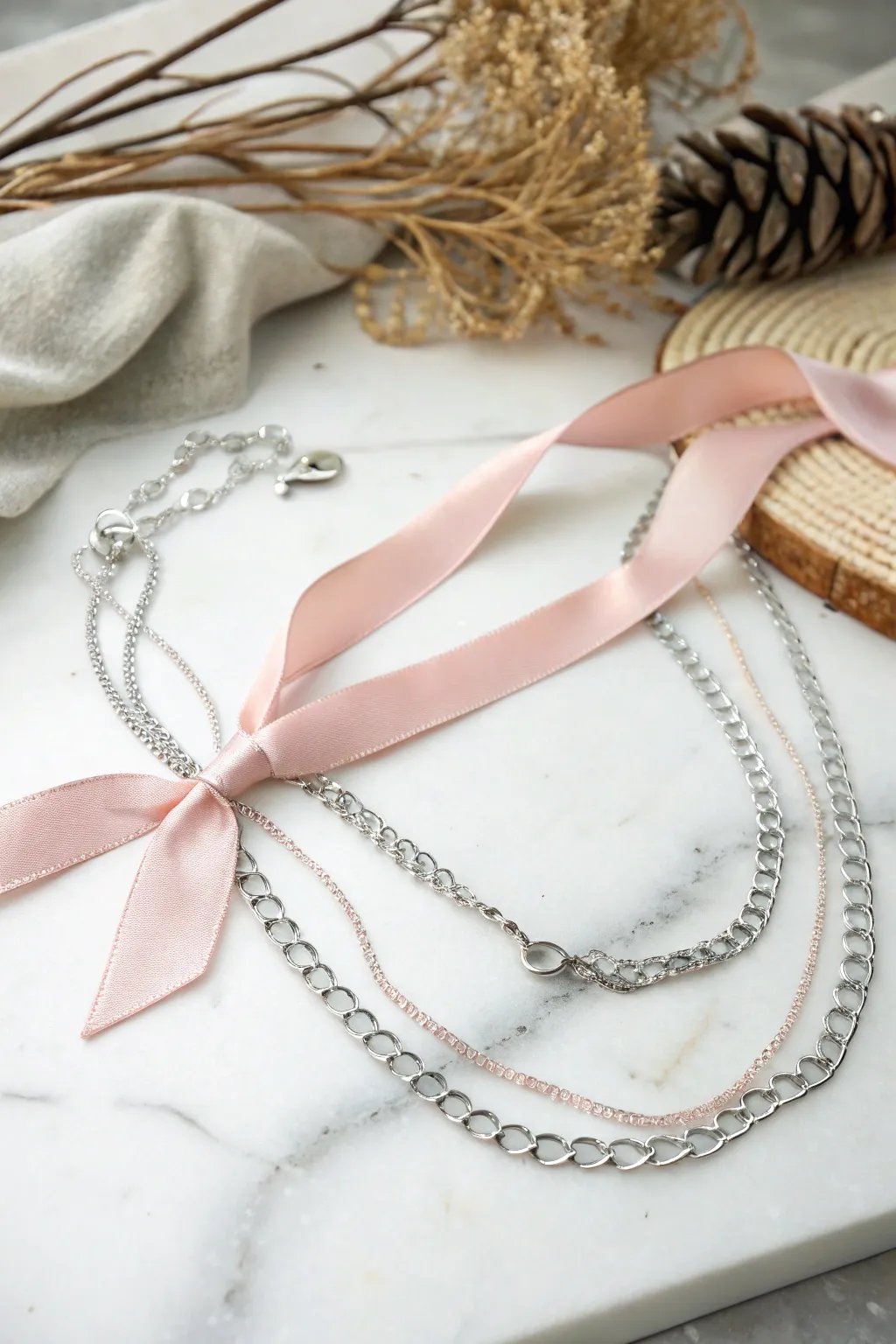 Discover the elegance of contrast with our ribbon and chain necklace, a perfect blend of softness and strength.