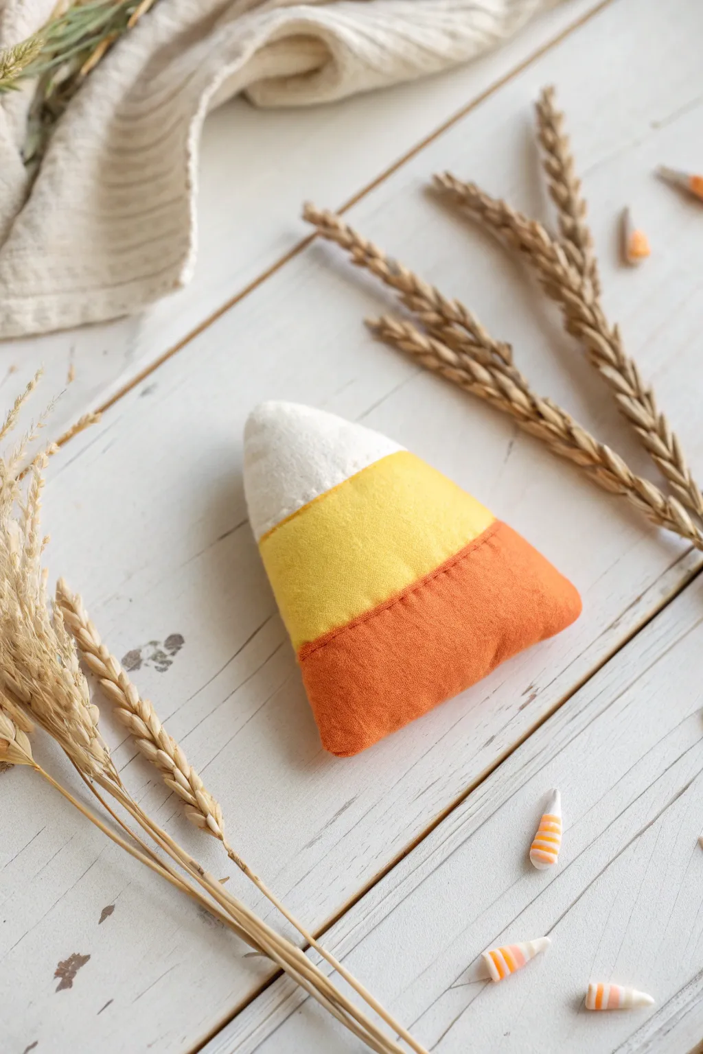 Embrace the cozy charm of handmade Halloween decor with this delightful fabric candy corn. Perfect for adding a touch of whimsy to your seasonal celebrations.