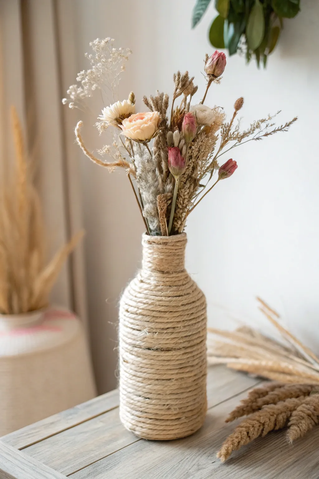Embrace rustic elegance: A twine-wrapped vase with dried blooms for a touch of farmhouse charm.