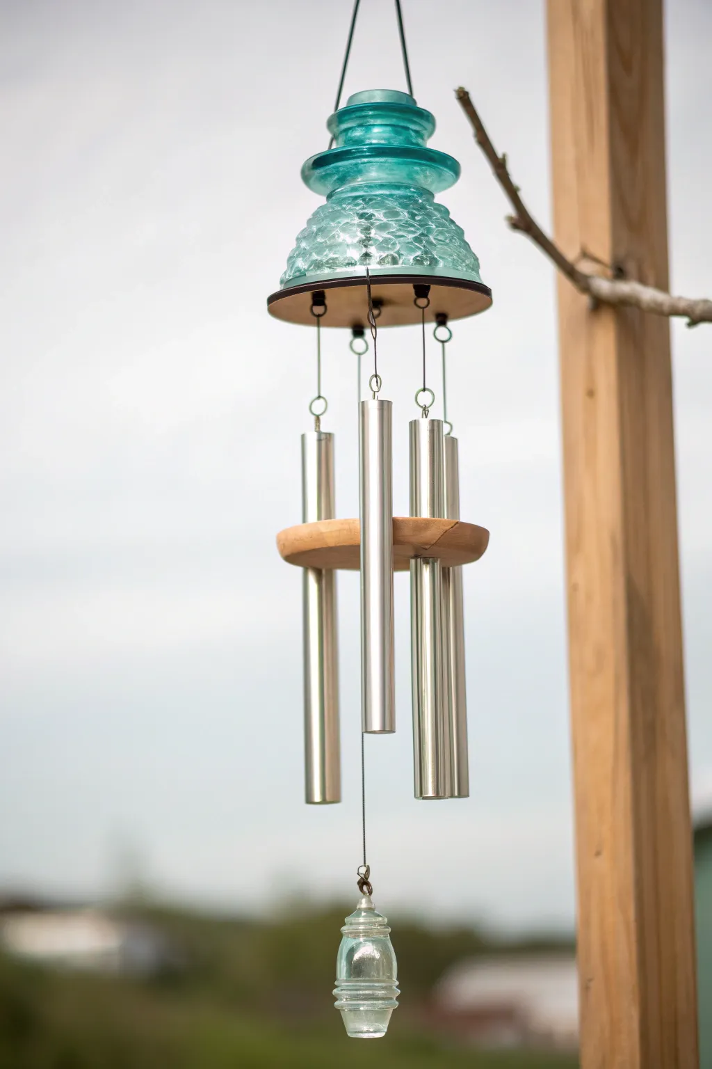 Embrace tranquility with a touch of whimsy—repurposed glass insulator wind chimes that sing a gentle melody of elegance and simplicity.