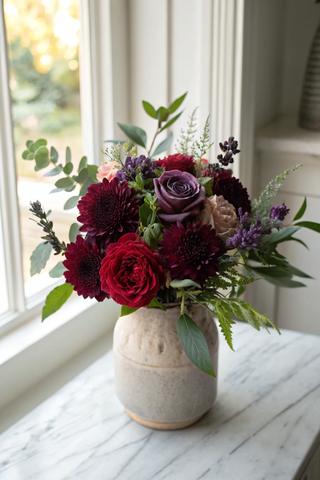 Elegantly mysterious: A dark floral centerpiece that captivates with deep reds and purples.