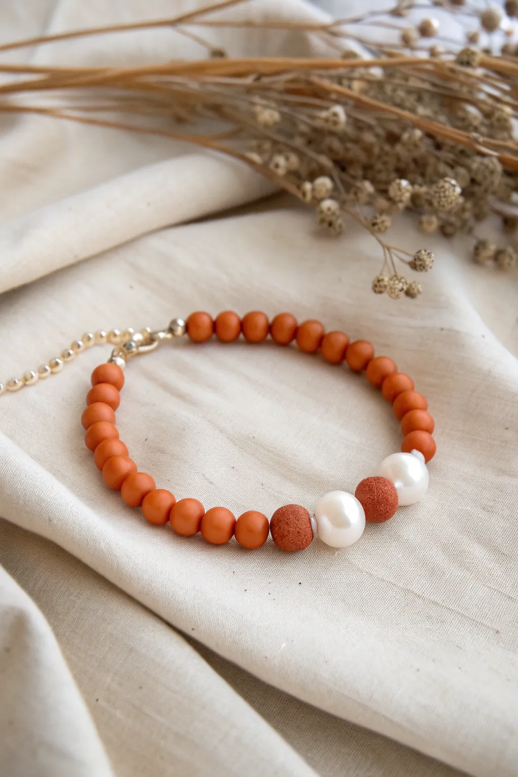 Sophisticated simplicity: Discover the charm of orange clay beads with a pearl accent.