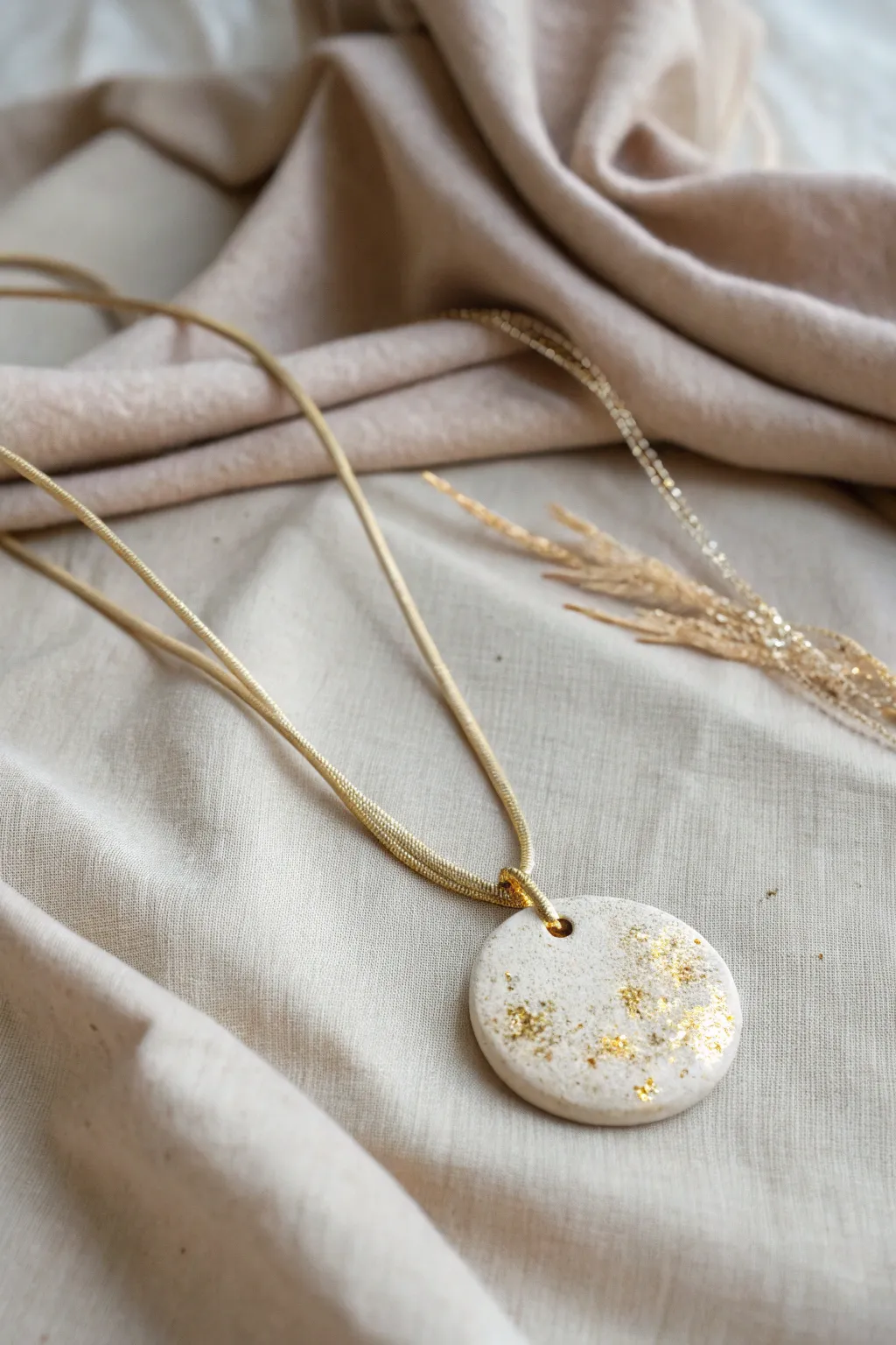Elevate your style with a touch of shimmer. This clay necklace combines minimalist design with a sprinkle of glamour.