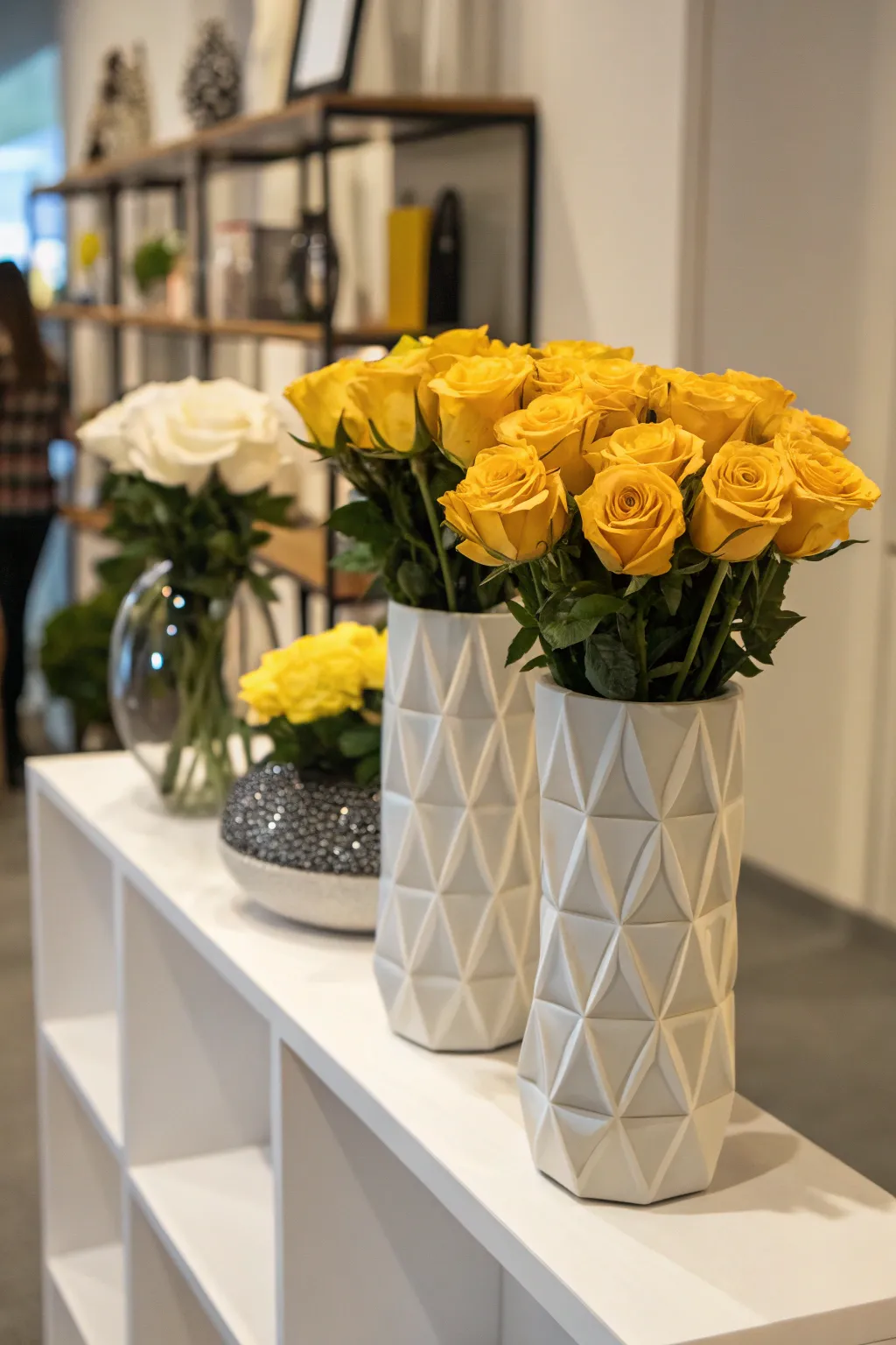 Modern art with yellow roses in geometric vases.