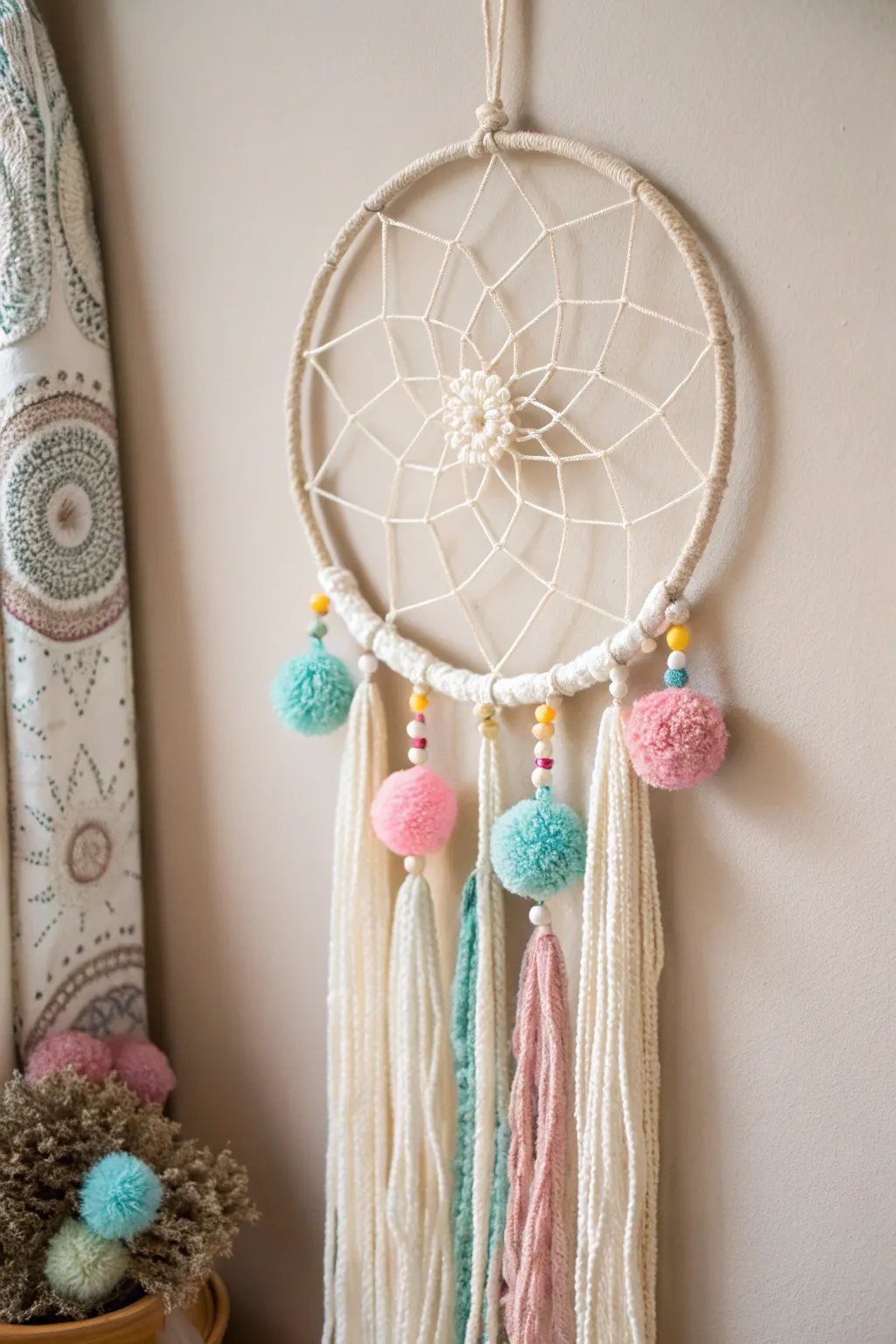 Add a splash of joy with a playful pom-pom dream catcher!