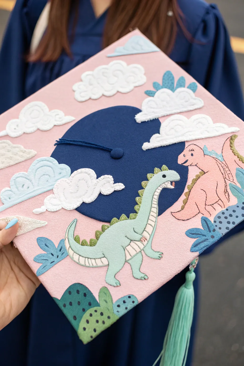 Embrace your whimsical side with a pastel dinosaur dreamscape on your graduation cap!