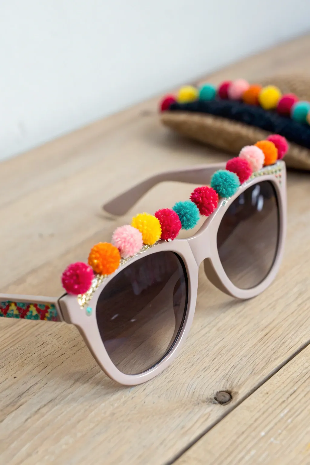 Add a burst of fun to your summer look with these charming pom pom sunglasses!