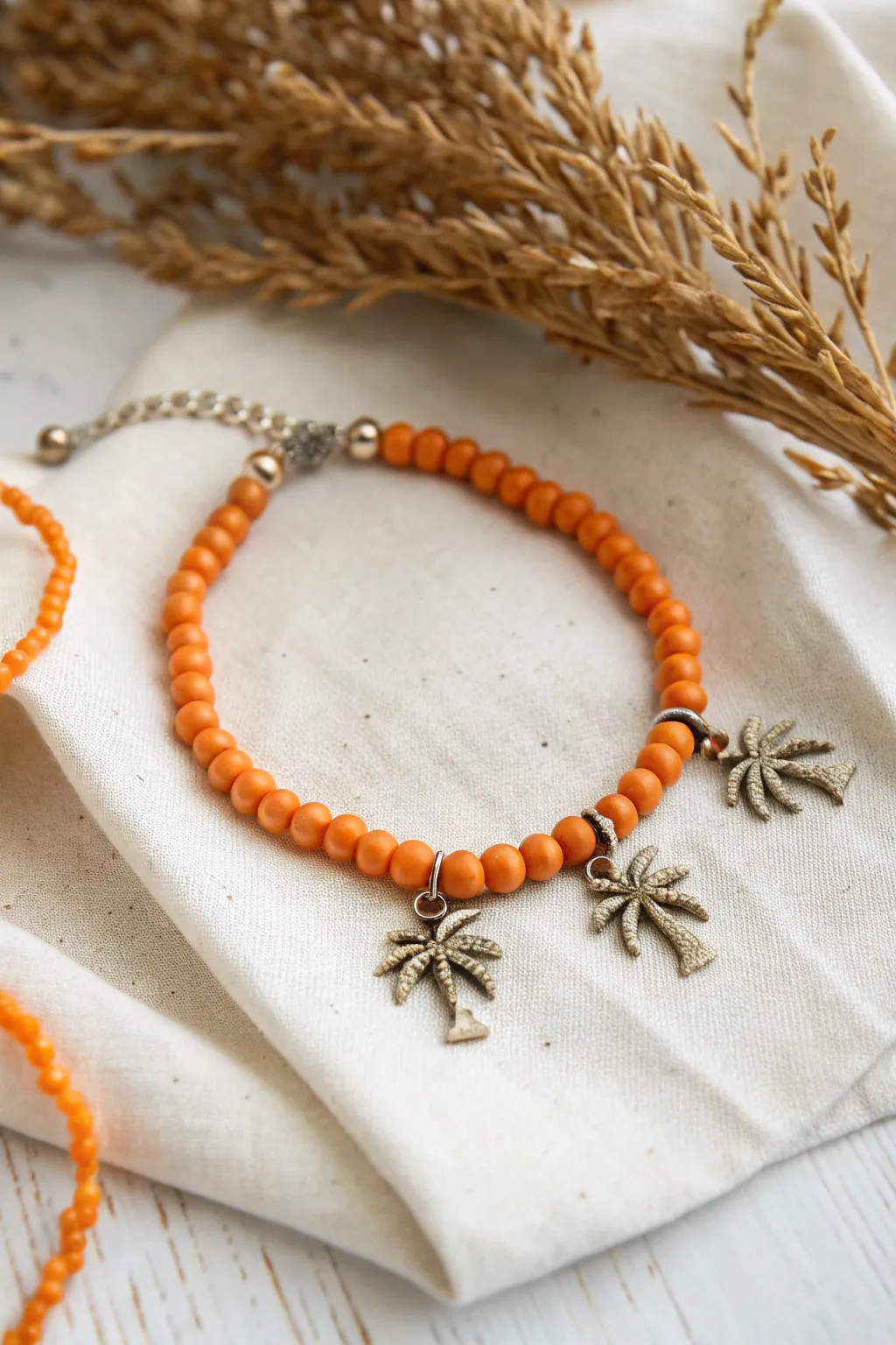 Embrace tropical charm with this exquisite orange clay bead bracelet, complete with delicate palm tree accents.