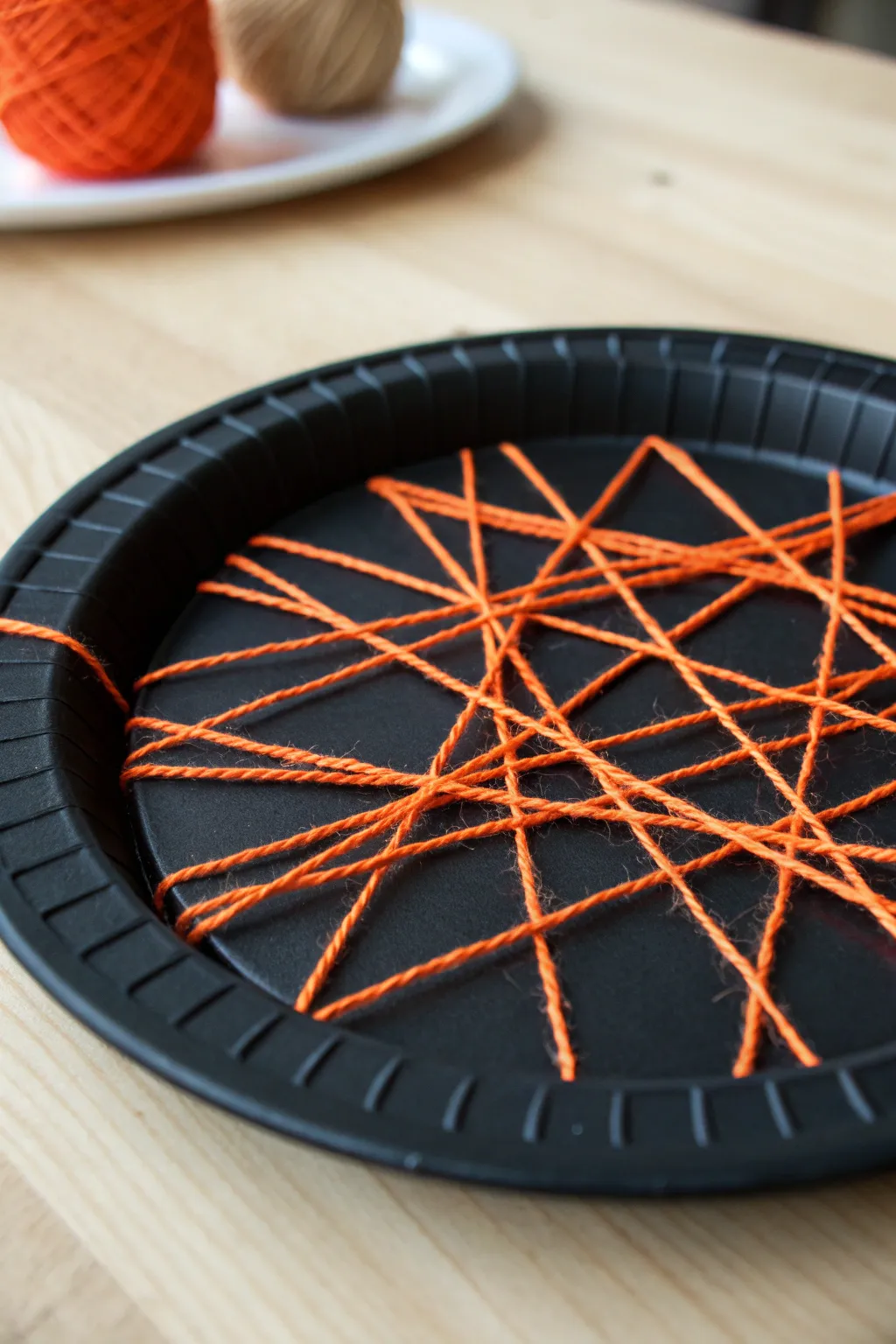 Craft your own minimalist masterpiece: A stunning paper plate spider web with a boho twist.