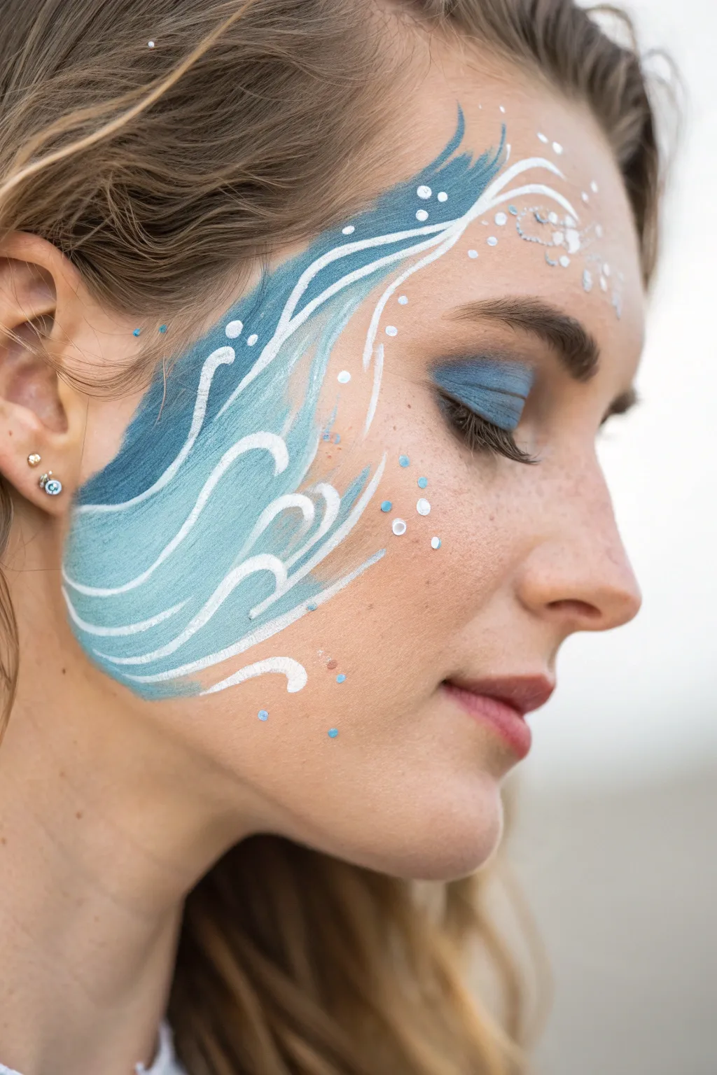 Embrace the serenity of the sea with this elegant ocean wave face paint design.