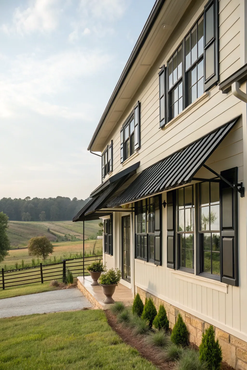 Bold black metal awnings make a striking statement against this farmhouse's exterior.