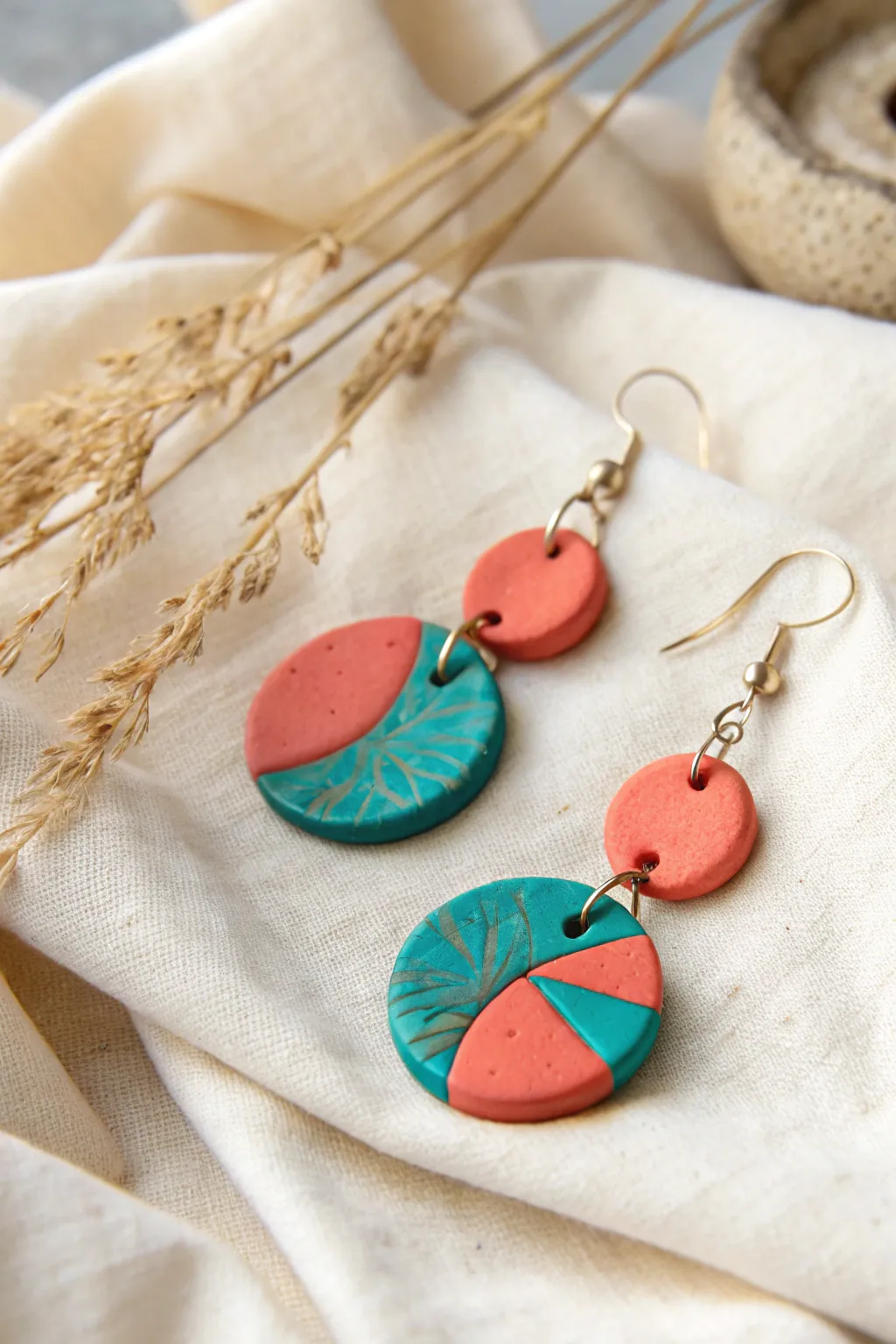 Elevate your style with these bold, handcrafted polymer clay earrings in striking teal and coral. Perfect for adding a touch of vibrant elegance to any outfit.