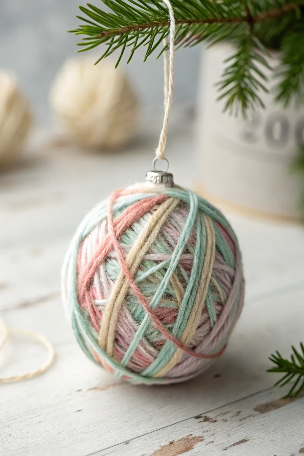 Elevate your holiday decor with handmade yarn-wrapped ornaments, bringing a touch of cozy craftsmanship to your minimalist Christmas tree.