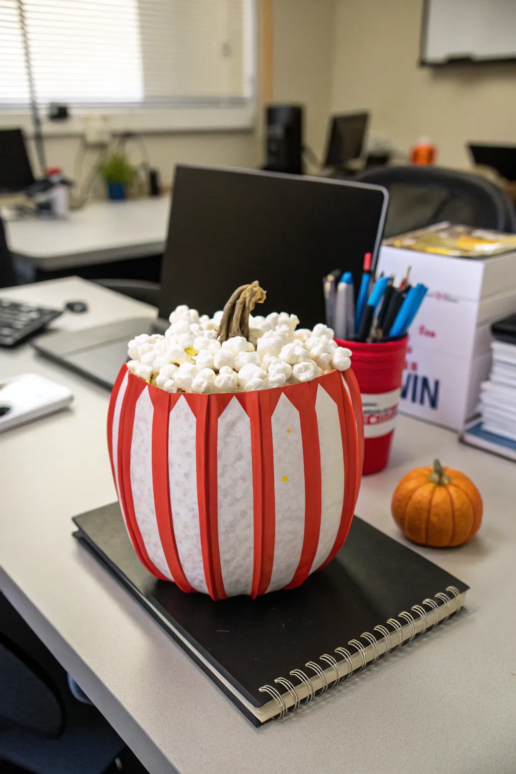 A retro popcorn bucket pumpkin, perfect for cinema fans in the office.