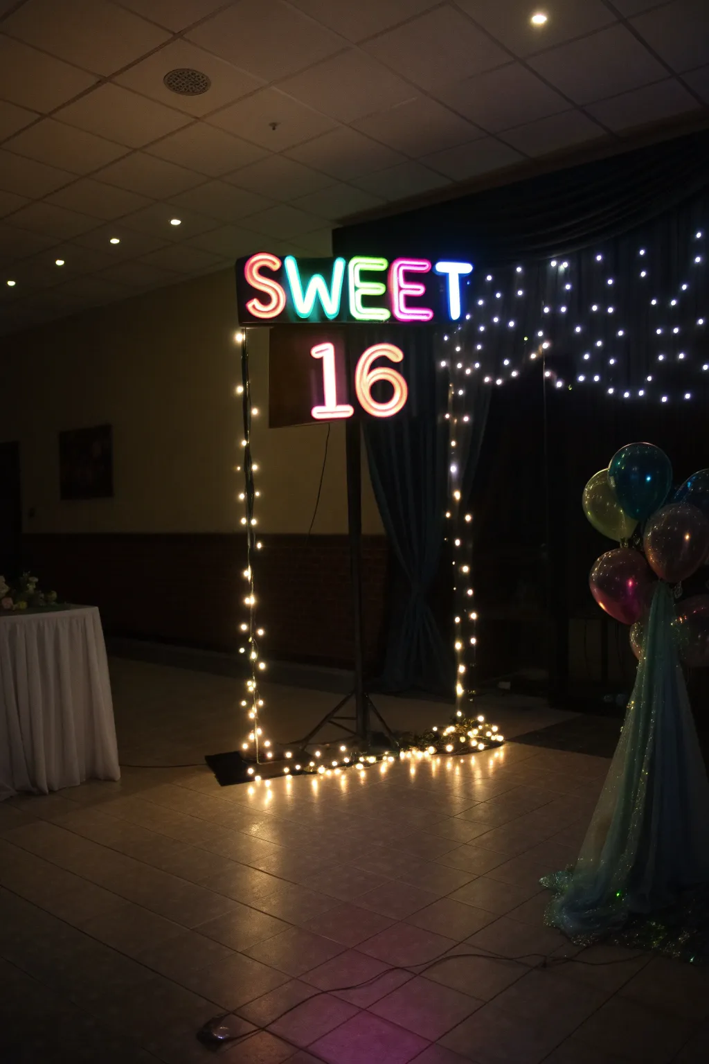 A striking 'Sweet 16' neon sign adds a modern and vibrant touch to the decor.