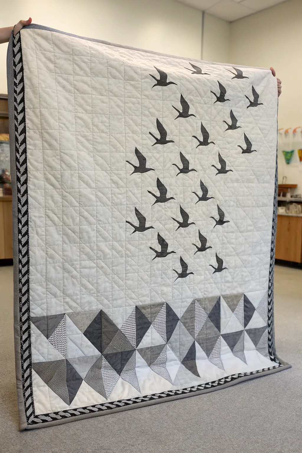 A minimalist monochrome quilt with elegant flying geese borders.