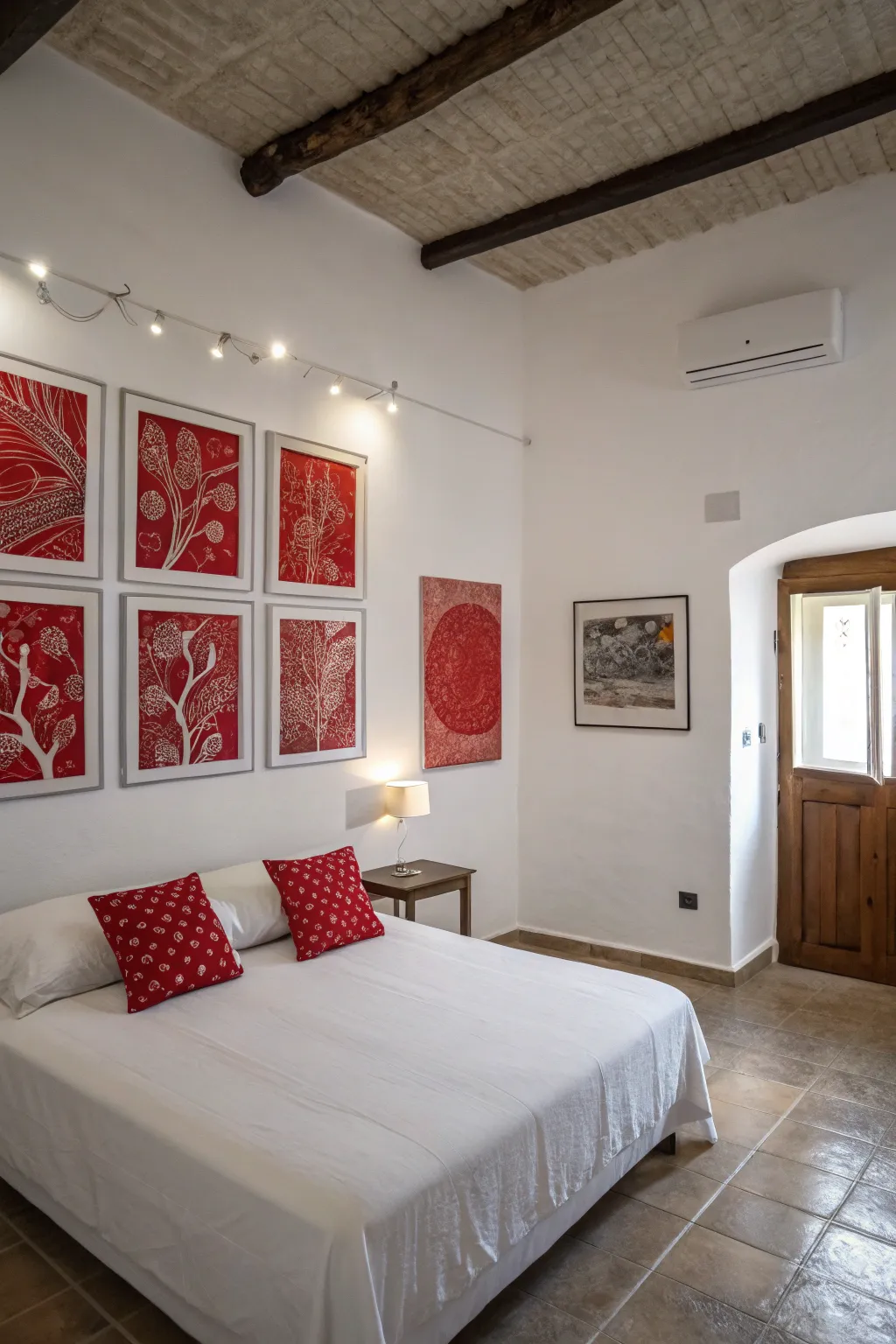 Minimalist red art pieces add sophistication and personality to a white bedroom.