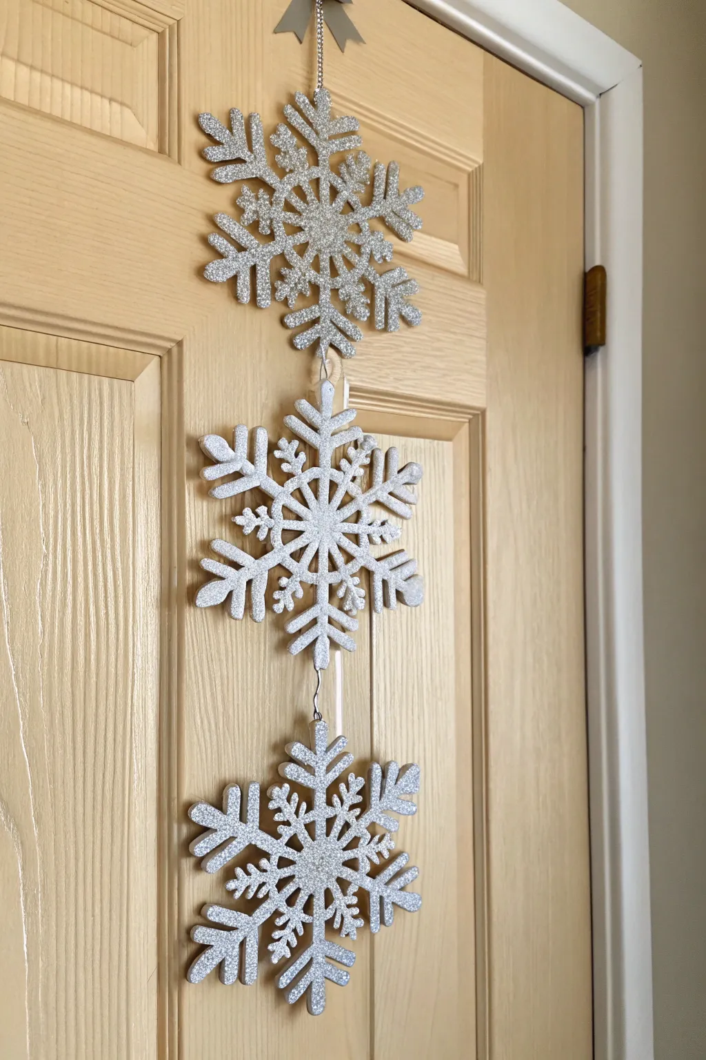 Embrace the magic of a Snowflake Wonderland with this elegant, handcrafted door hanger.