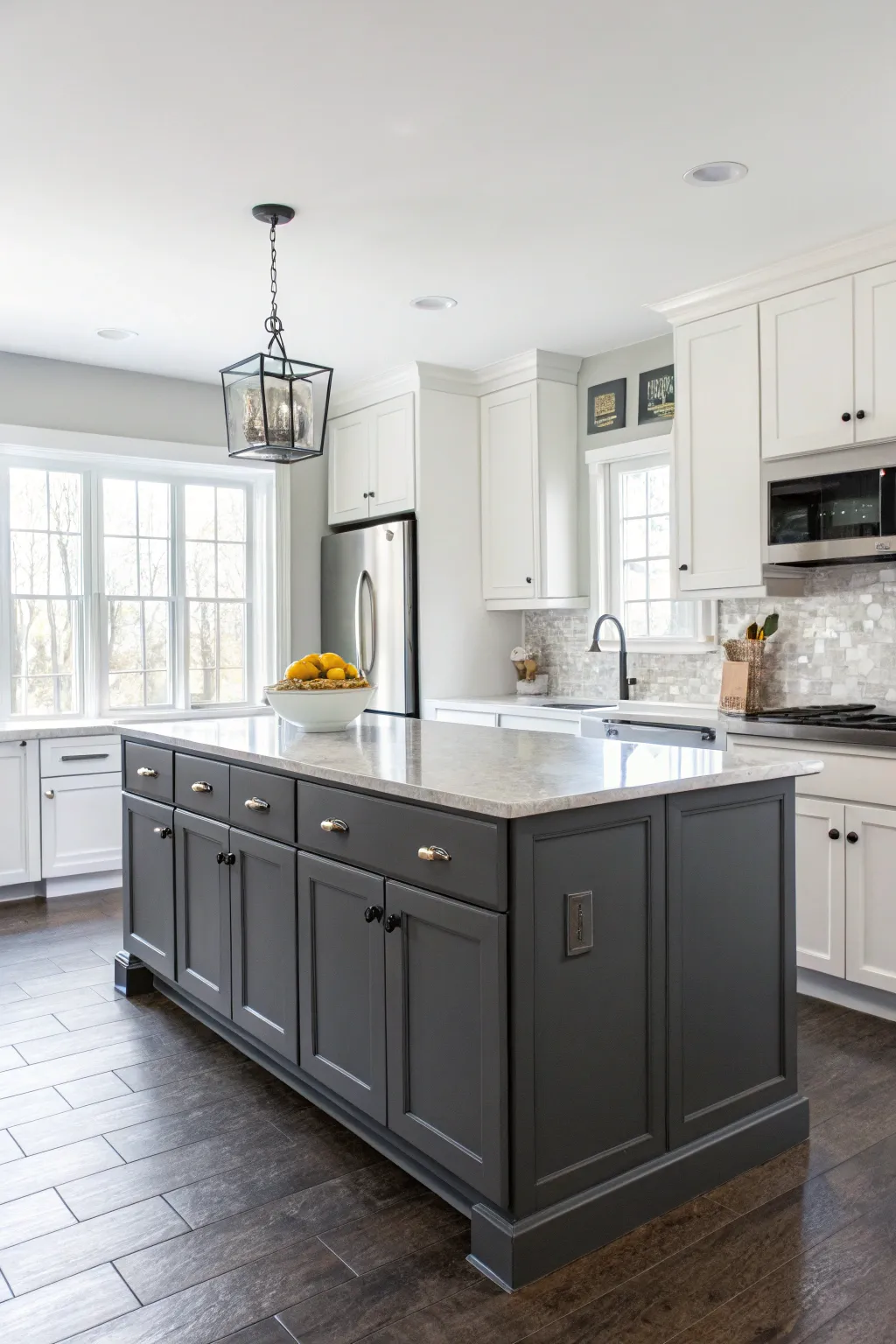 A kitchen with a sophisticated charcoal gray island paired with white cabinets.