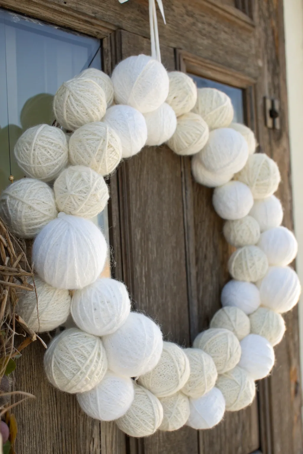 Welcome warmth and whimsy with this charming yarn snowball wreath, a cozy touch for your front door.