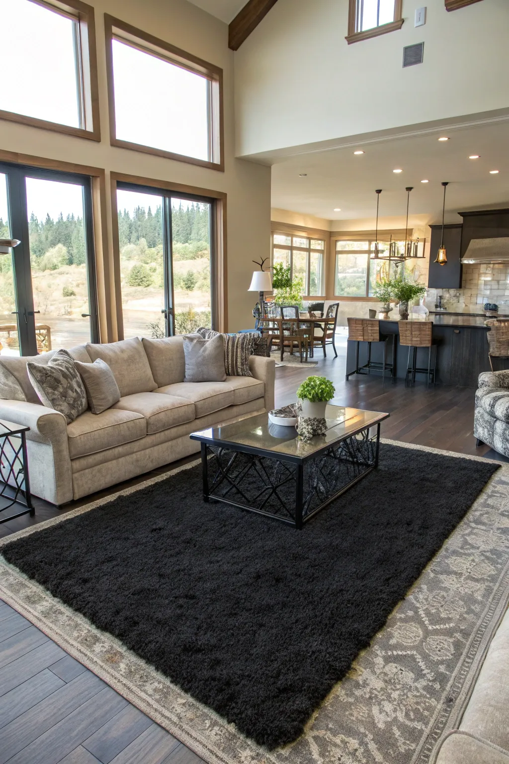 Black rugs help define and organize spaces within an open layout.