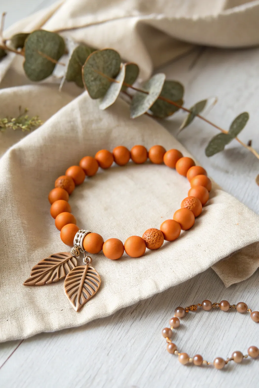 Embrace the beauty of nature with this stunning orange clay and leaf bead bracelet, a perfect blend of minimalist and Boho style.