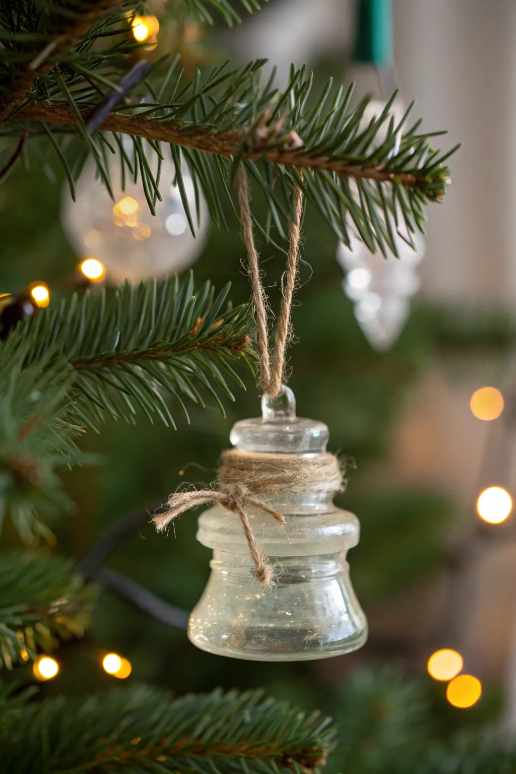 Elevate your holiday decor with the timeless charm of repurposed glass insulators, perfect for a touch of minimalist elegance.