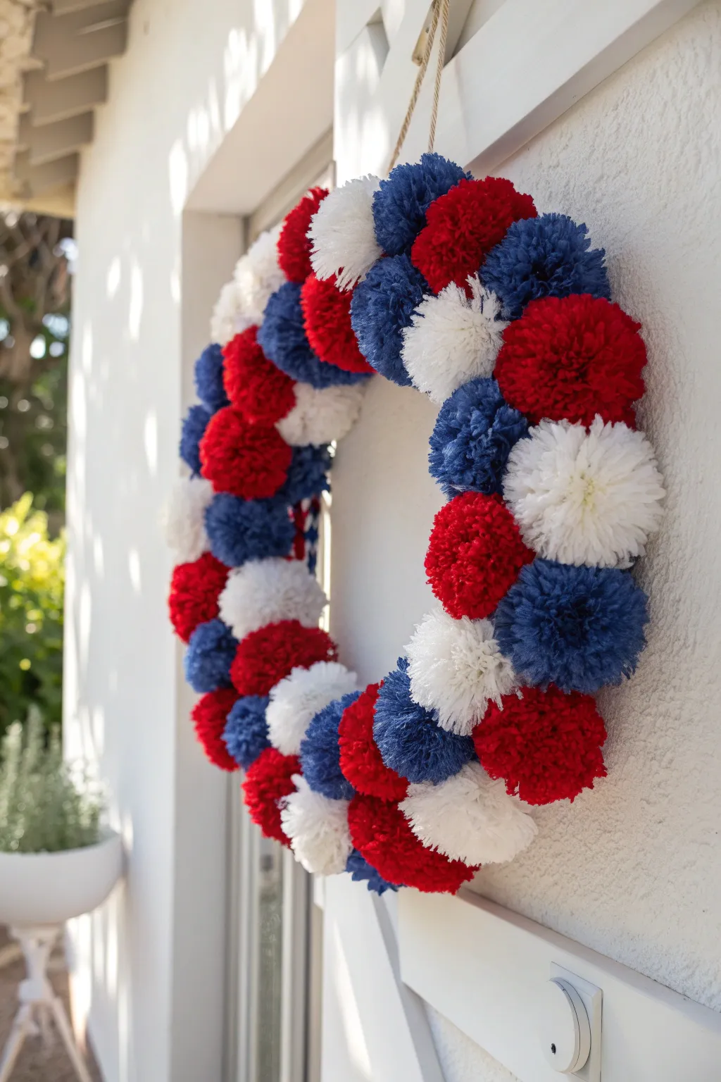 Add a burst of patriotic flair to your decor with this charming pom-pom wreath, perfect for a touch of playful elegance.