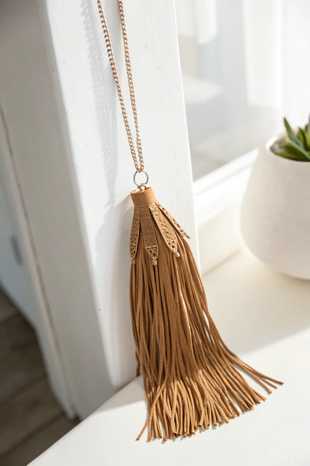 Elevate your style with this fringed leather pendant—where minimalist meets boho chic.