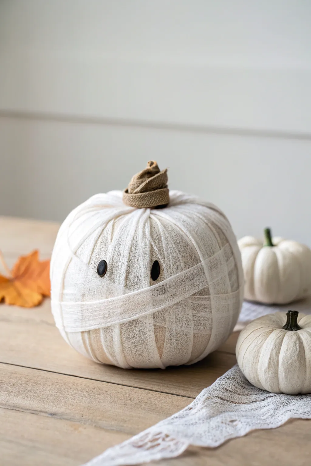 Meet your new autumn muse: a mummy pumpkin adorned with a tiny hat, where minimalist charm meets boho flair.