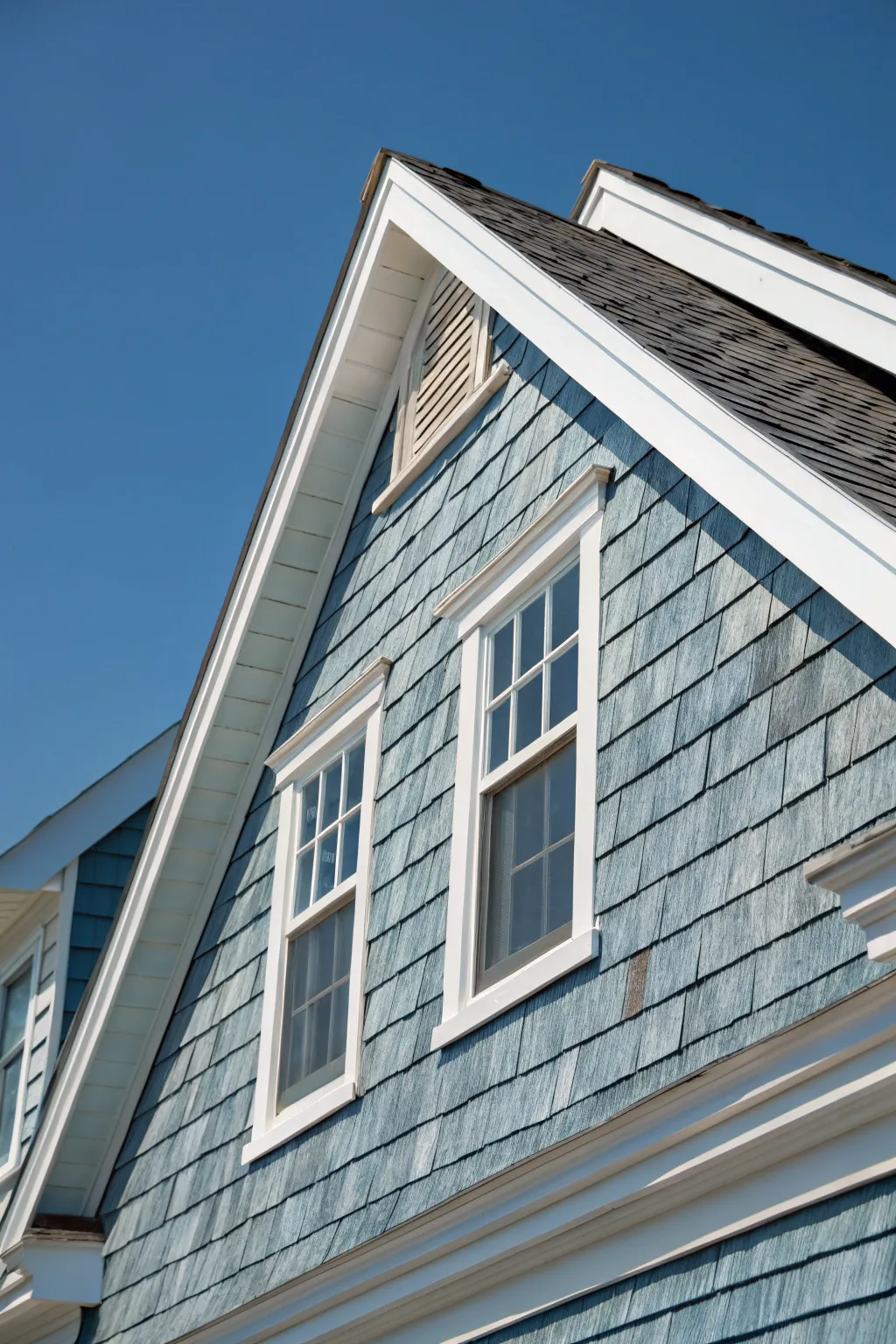 Transport yourself to the seaside with this stunning blue-gray cedar-shake gable, perfectly capturing the essence of coastal living.
