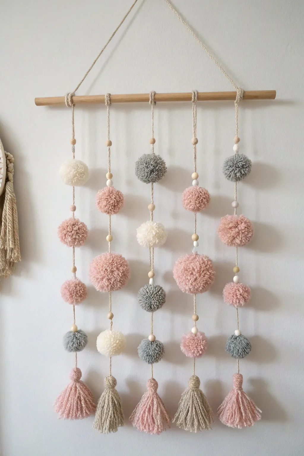 Add a touch of playful elegance to your space with this handcrafted pom pom wall hanging.