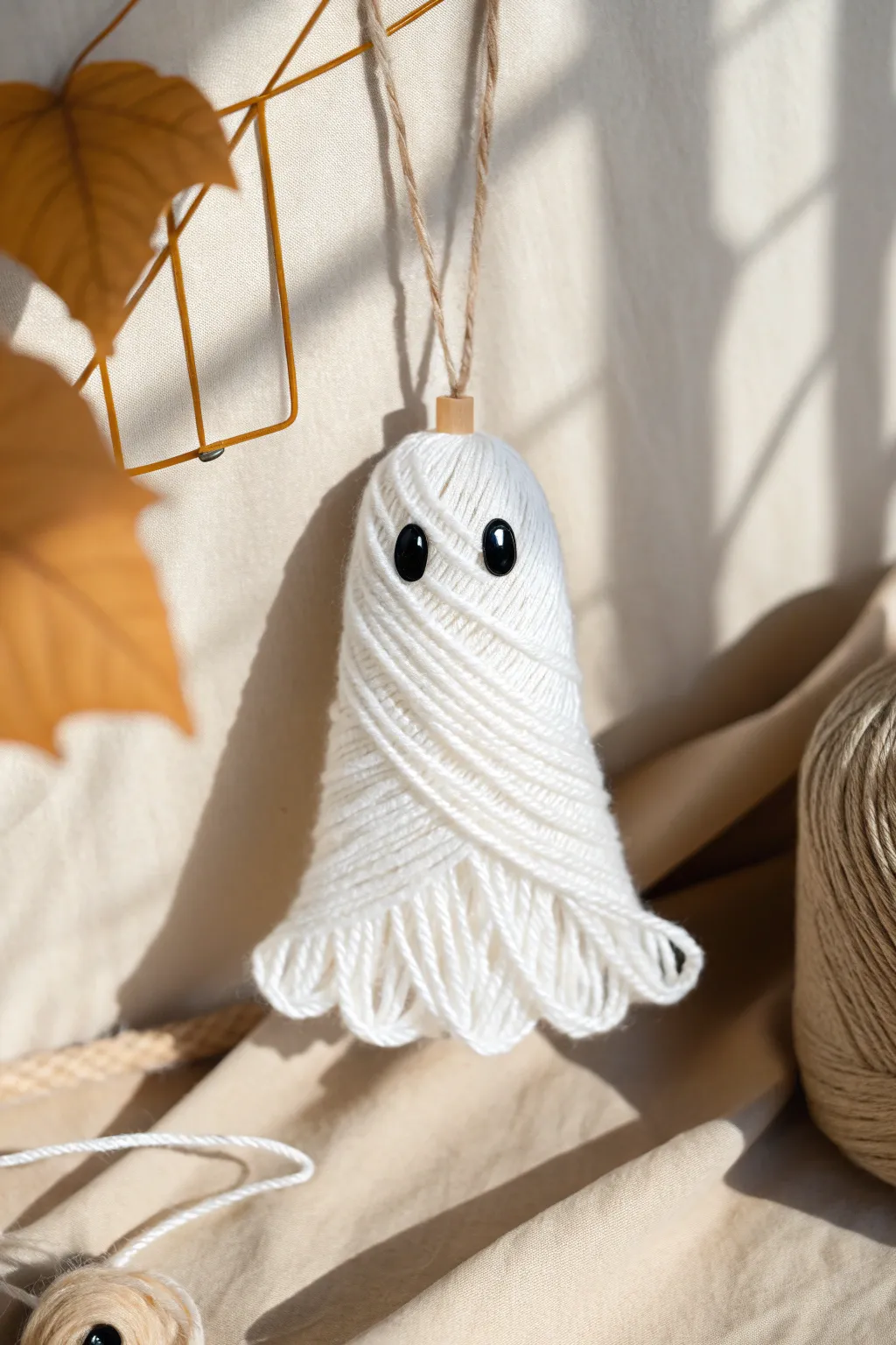 Embrace minimalist charm with these delightful yarn-wrapped ghosts, perfect for adding a touch of whimsy to your Halloween decor.