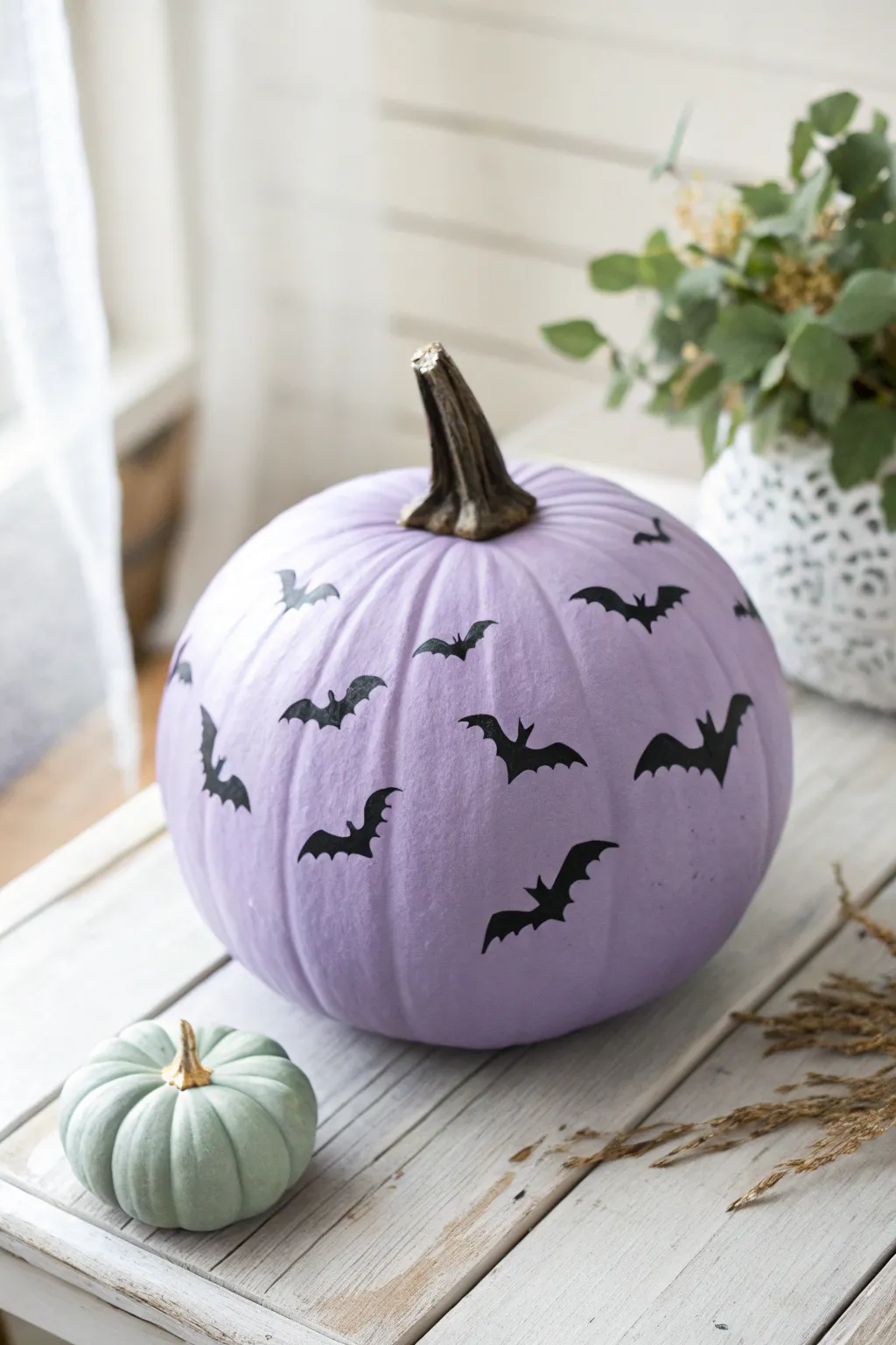 Elevate your Halloween decor with a minimalist purple pumpkin featuring graceful bats in flight.